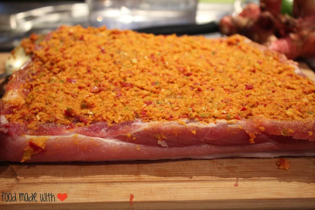 Spice paste evenly spread on the meat side of the pork belly